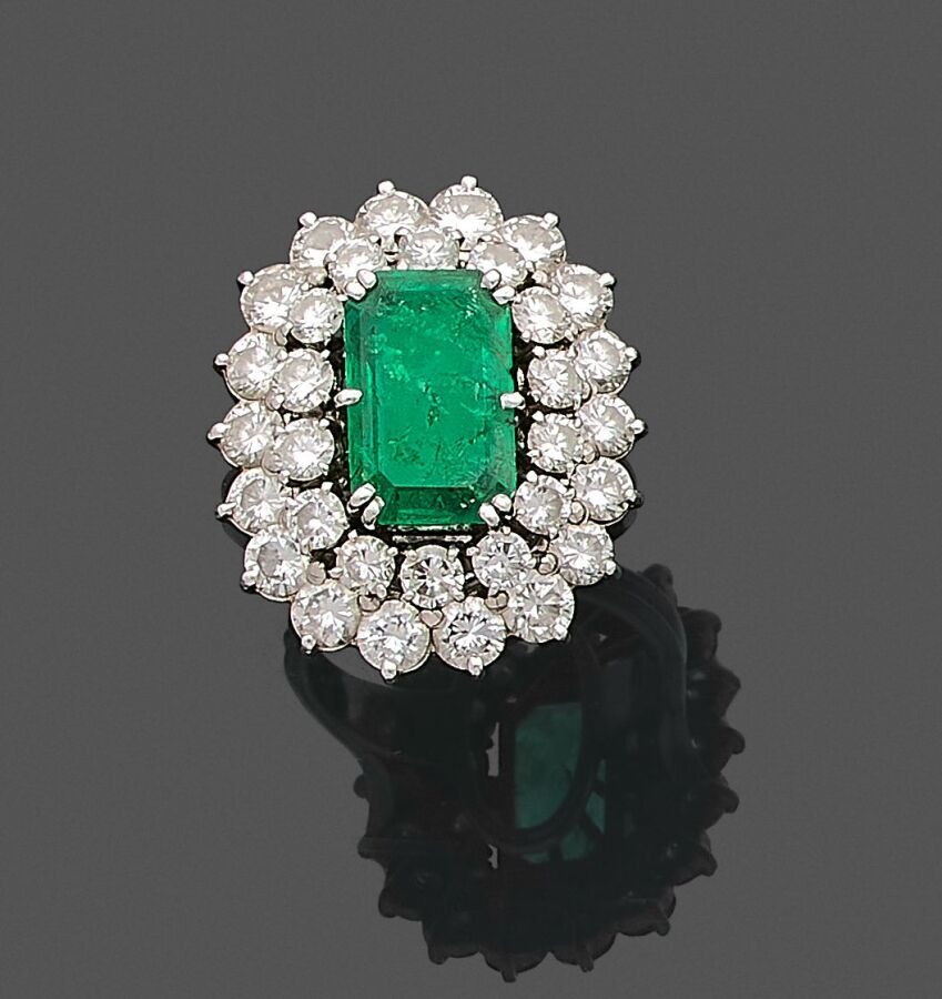 Null 一枚850千分之一的铂金戒指，中间是一颗长方形的祖母绿，周围是圆形明亮式切割钻石。
(表面有划痕、缺损和结霜）。
手指大小：52
毛重 : 12,6 &hellip;