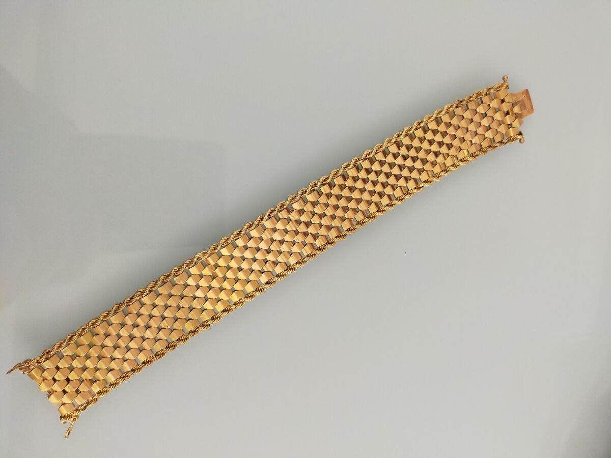 Null 黄金750千分之一的灵活手镯丝带，两个扭曲的金属丝之间的平原中心。
(磨损和修复的痕迹）。
长度：20厘米
毛重 : 58,9 g