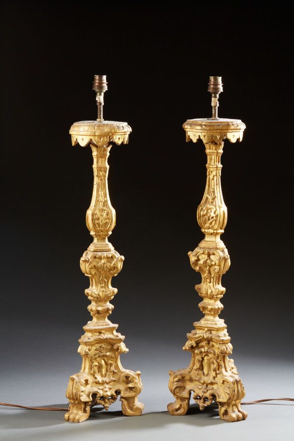 Null Paire de pique-cierges tripodes en bois mouluré, sculpté et doré à décor de&hellip;