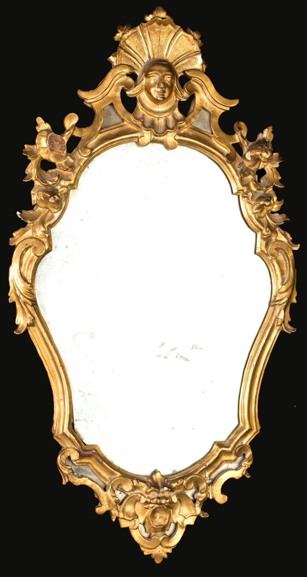 Mirror in carved and gilded wood, 18th century 有形状的框架，装饰有植物和花的浮雕；盖子的中心是一个面具