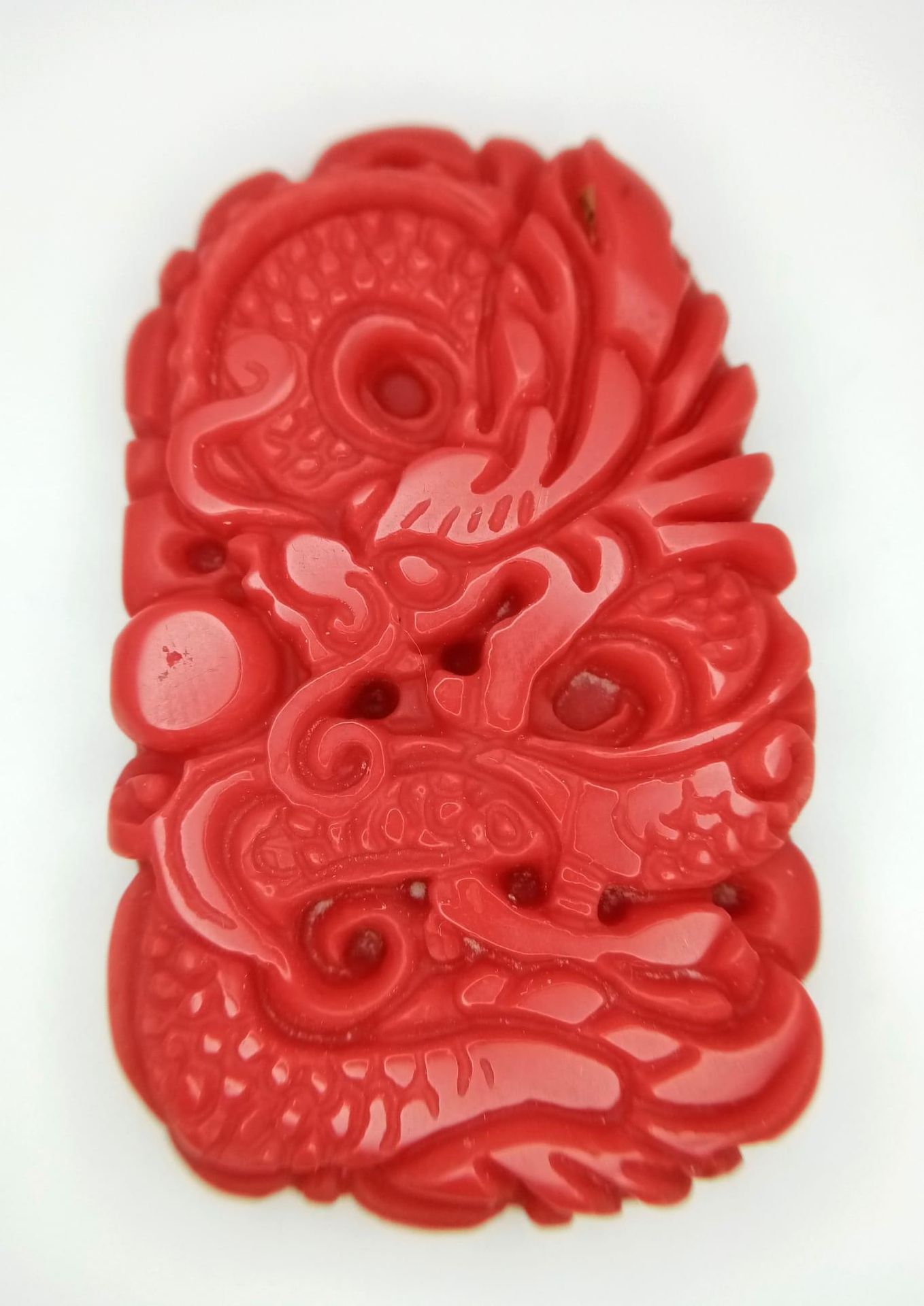 Null Pendentif en forme de dragon sculpté en jade rouge. 5cm.