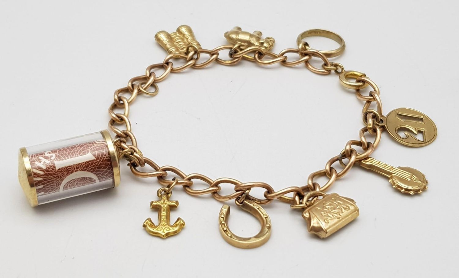Null A 9K Gold Charm Bracelet. 10 charms including: 10 shilling note, handbag an&hellip;
