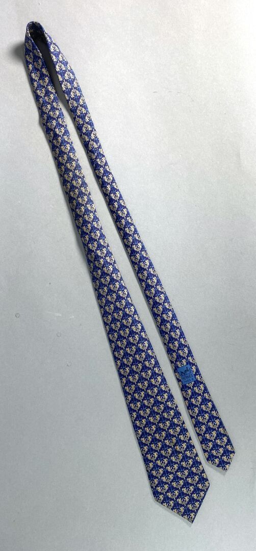 Null HERMES - Cravate en soie à motifs sur fond bleu. 
ATTENTION : Le retrait de&hellip;