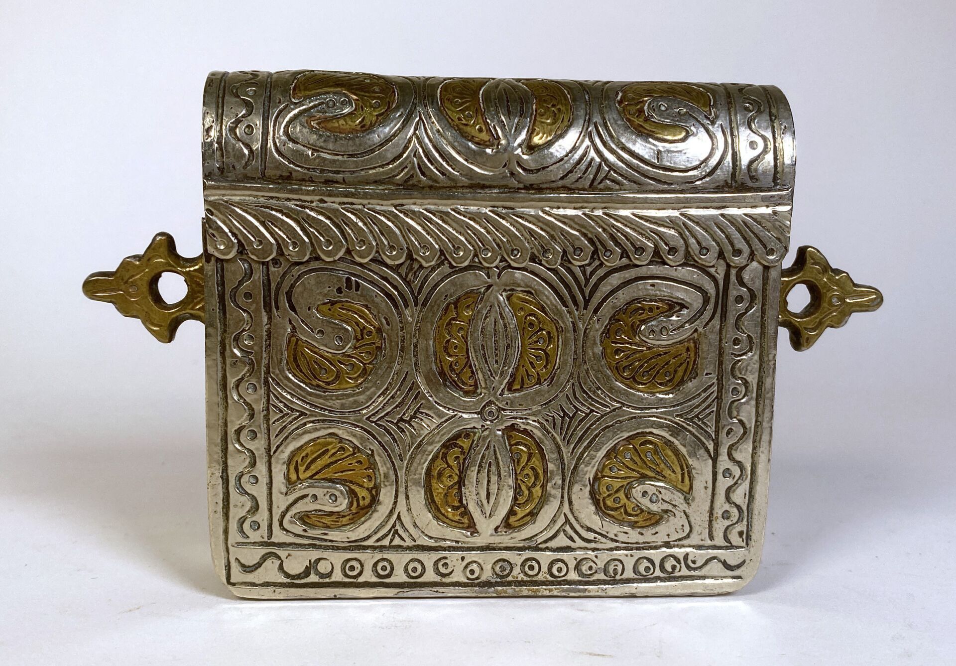 Null 四方形古兰经架，带圆形铰链盖和两个侧挂架，装饰有切割和錾刻的银片，银片上的风格化花卉图案与黄色铜身形成鲜明对比。 

摩洛哥 - 19 世纪

毛重：&hellip;