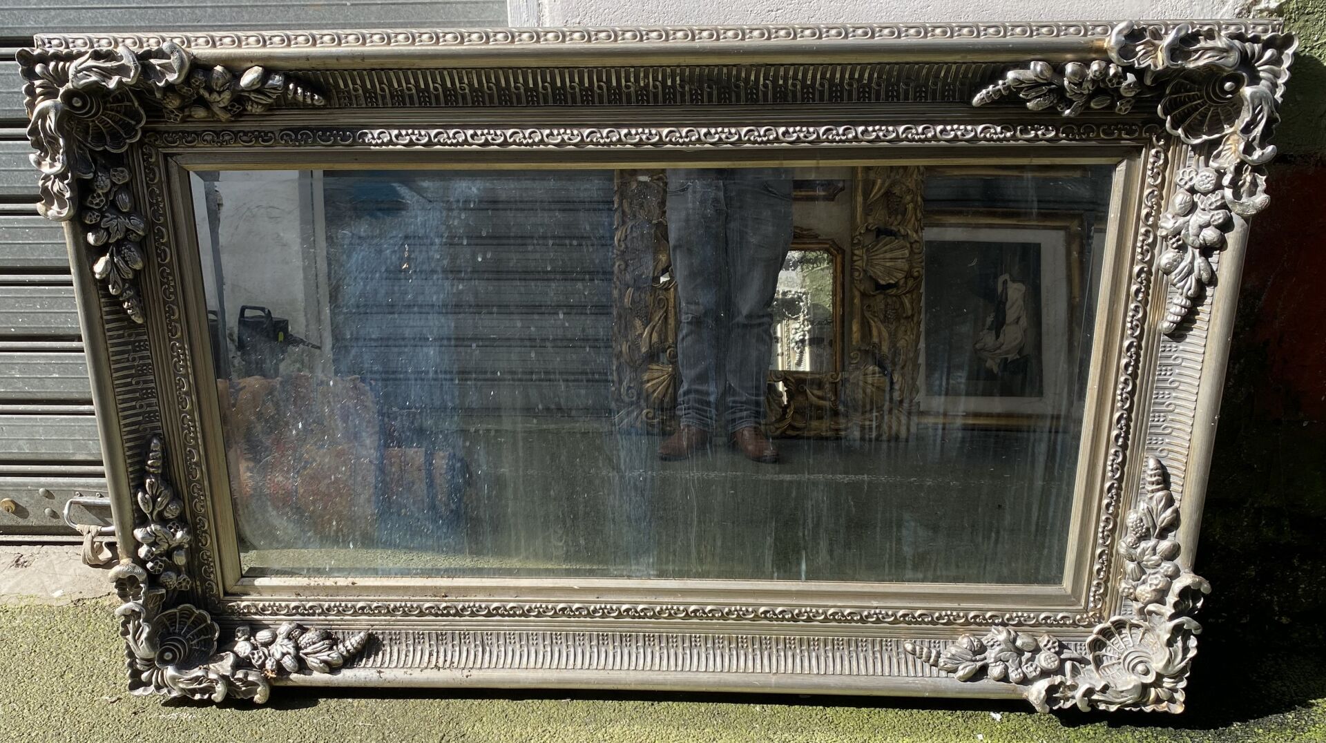 Null Grand miroir en bois argenté, les écoinçons à décor de coquilles et guirlan&hellip;