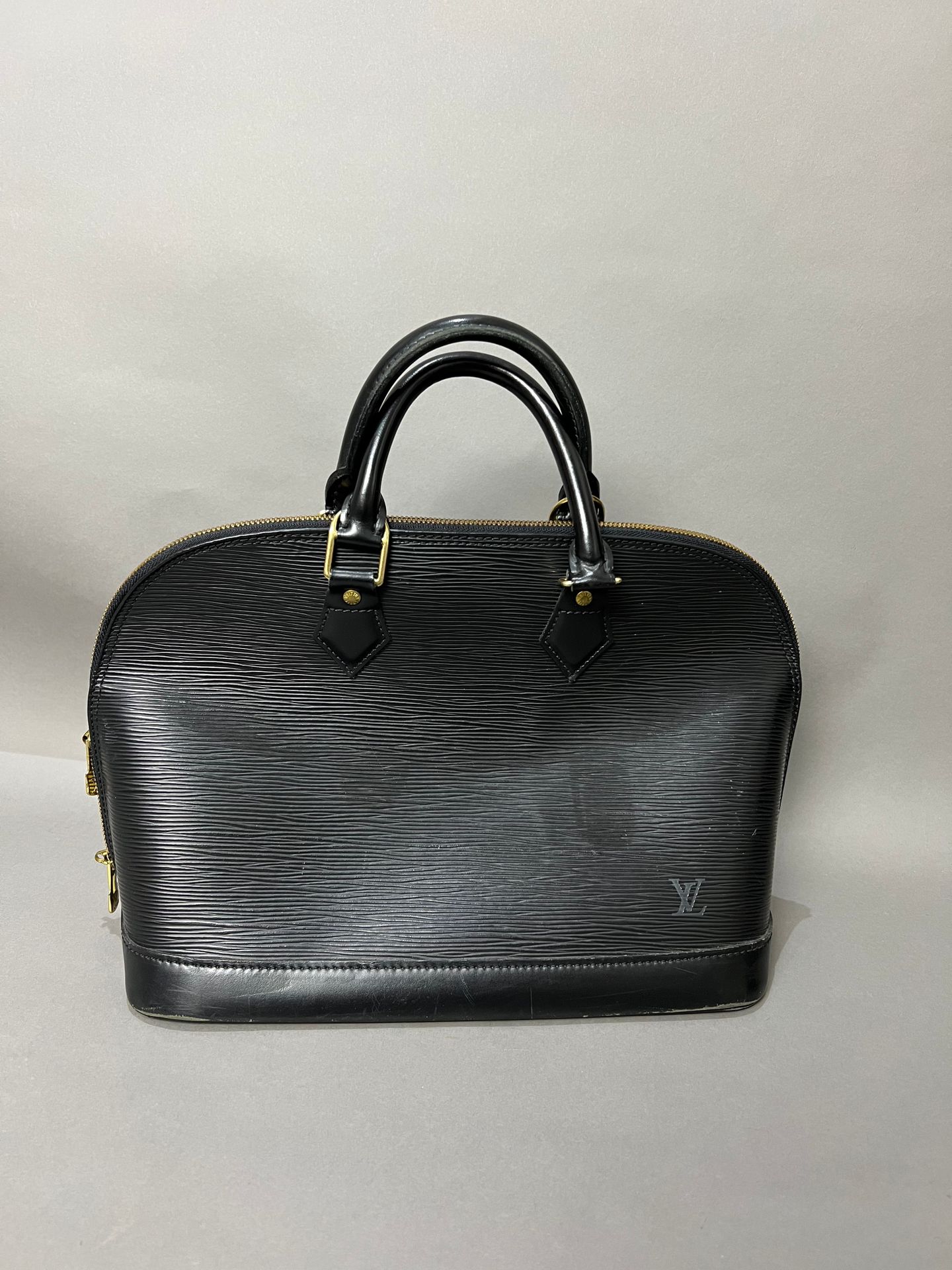 LOUIS VUITTON. Black epi leather bag, Alma model, gild…