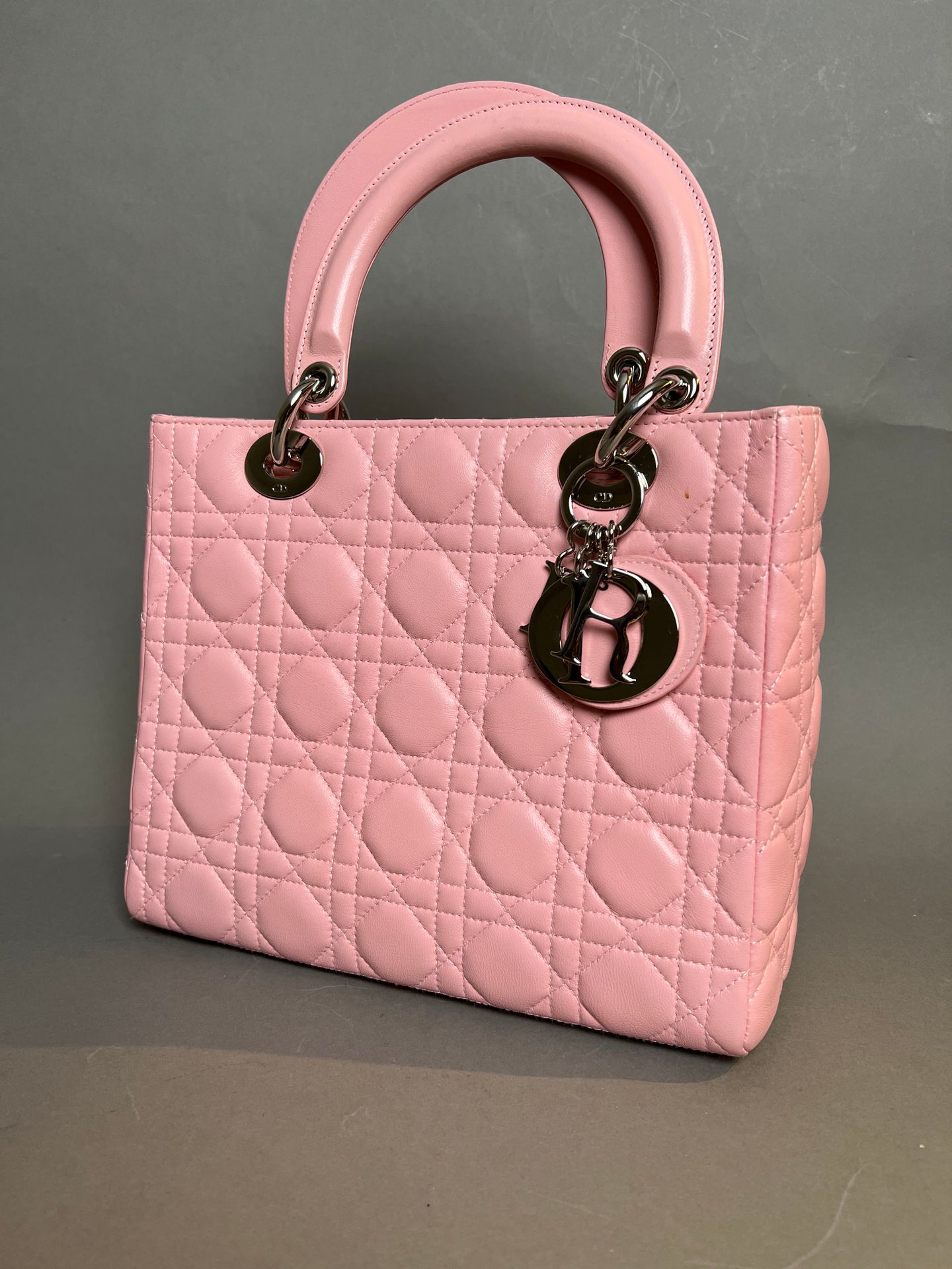 Null 克里斯蒂安-迪奥。粉红色藤条皮包，"Lady Dior "型号，带有银色吊饰吊坠。21 x 24厘米。尘袋。状况非常好。