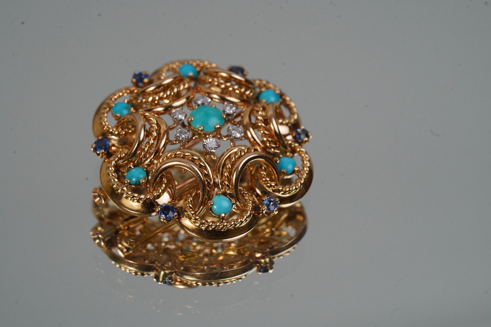 Null Spilla in oro con turchesi, diamanti e zaffiri incastonati. D. 20,28 g.