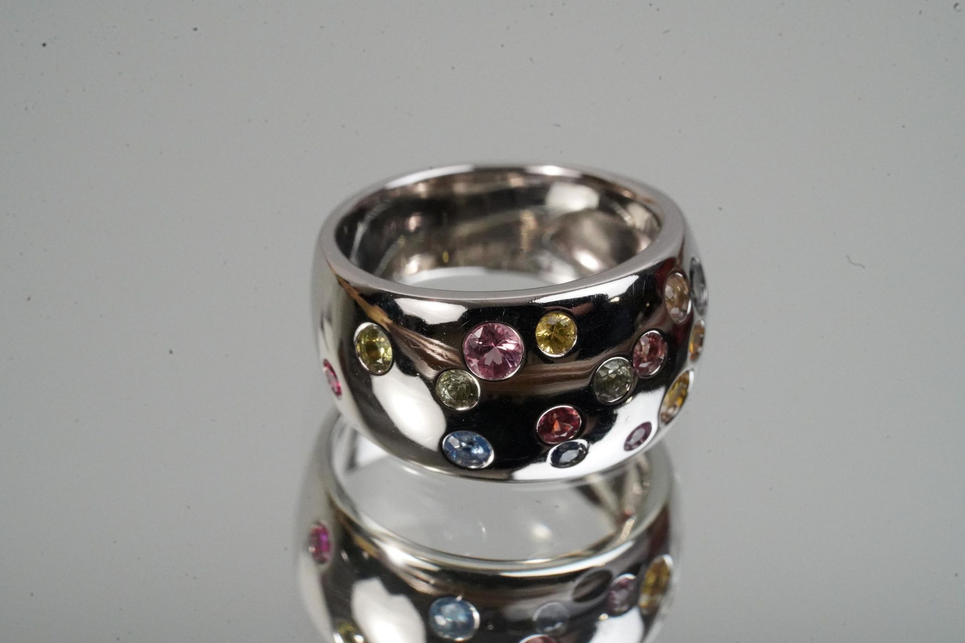 Null White gold ring set with small multicolored sapphires. P. 11.9 g. TD 53.