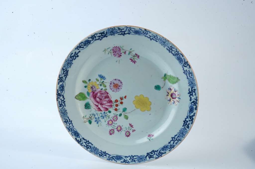 Null 中国。印度公司。珐琅彩瓷盘，带花。蓝色camaieu边框。18世纪。D. 22厘米。划痕