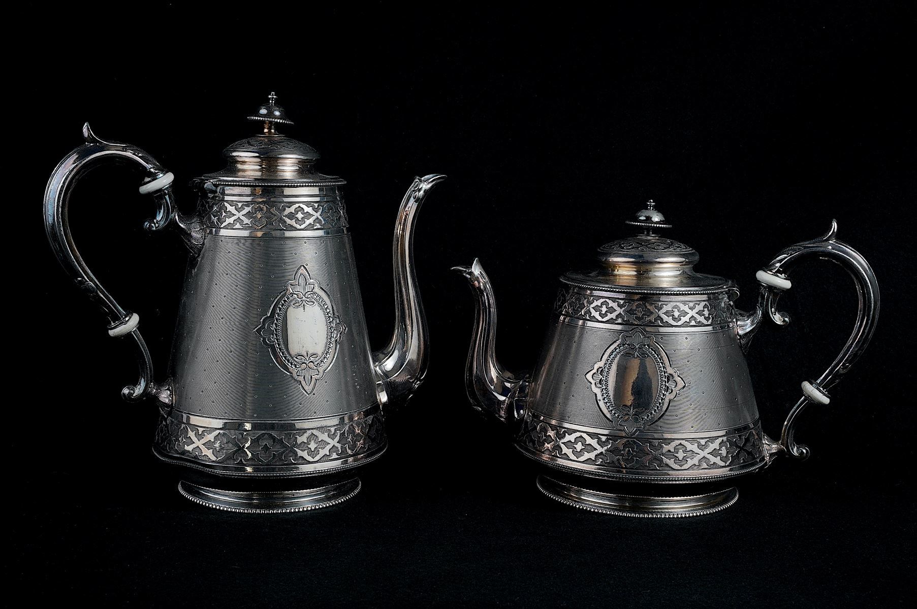 Null 一个镀银的咖啡壶和茶壶，上面装饰着奖章和叶子的浮雕。