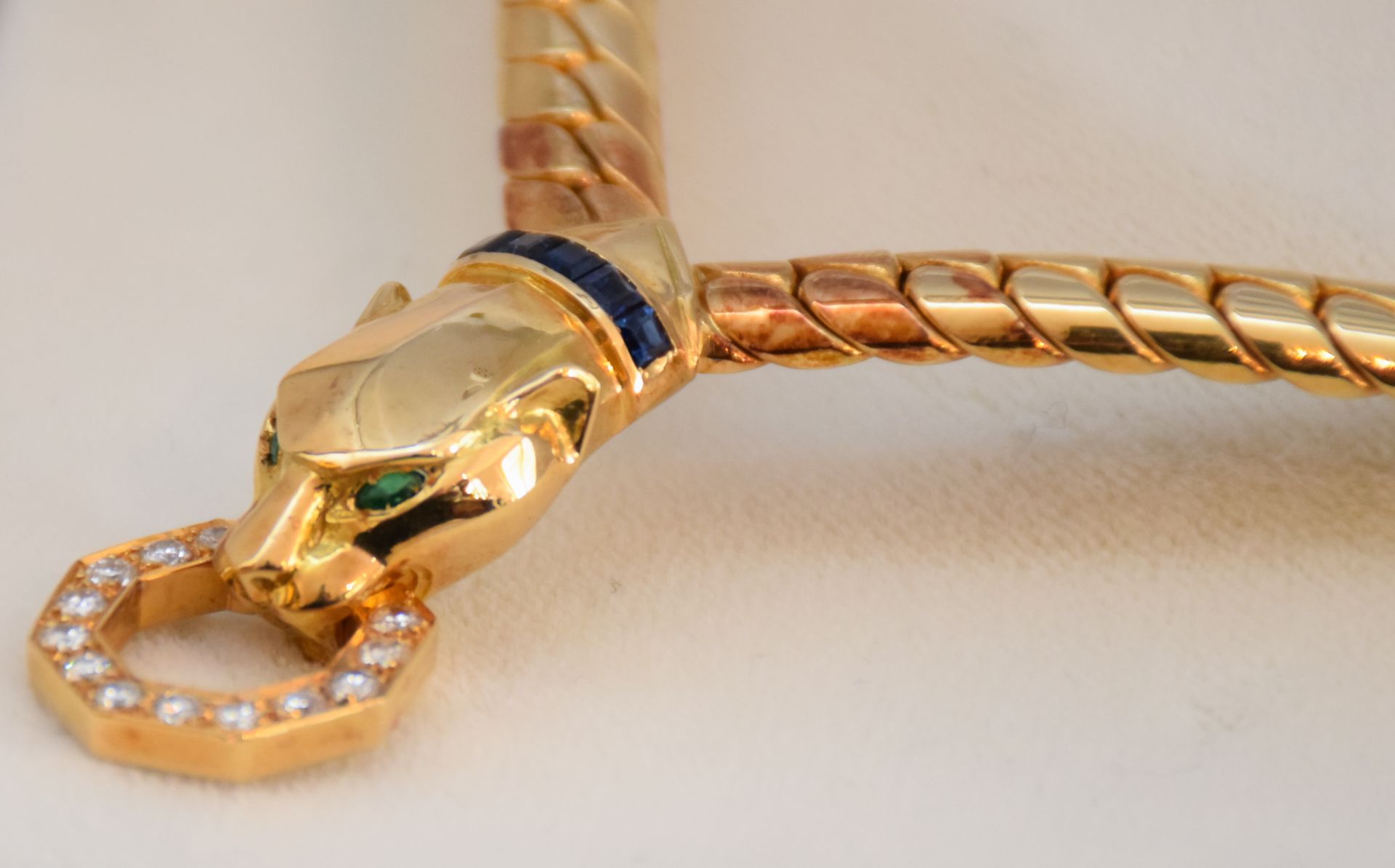 Null 18K（750）金项链，豹头图案，眼睛镶嵌着祖母绿，嘴里叼着一个镶嵌着圆形明亮式切割钻石的戒指，项链上装饰着校准的蓝宝石。毛重：52.3克 - 这颗珠&hellip;