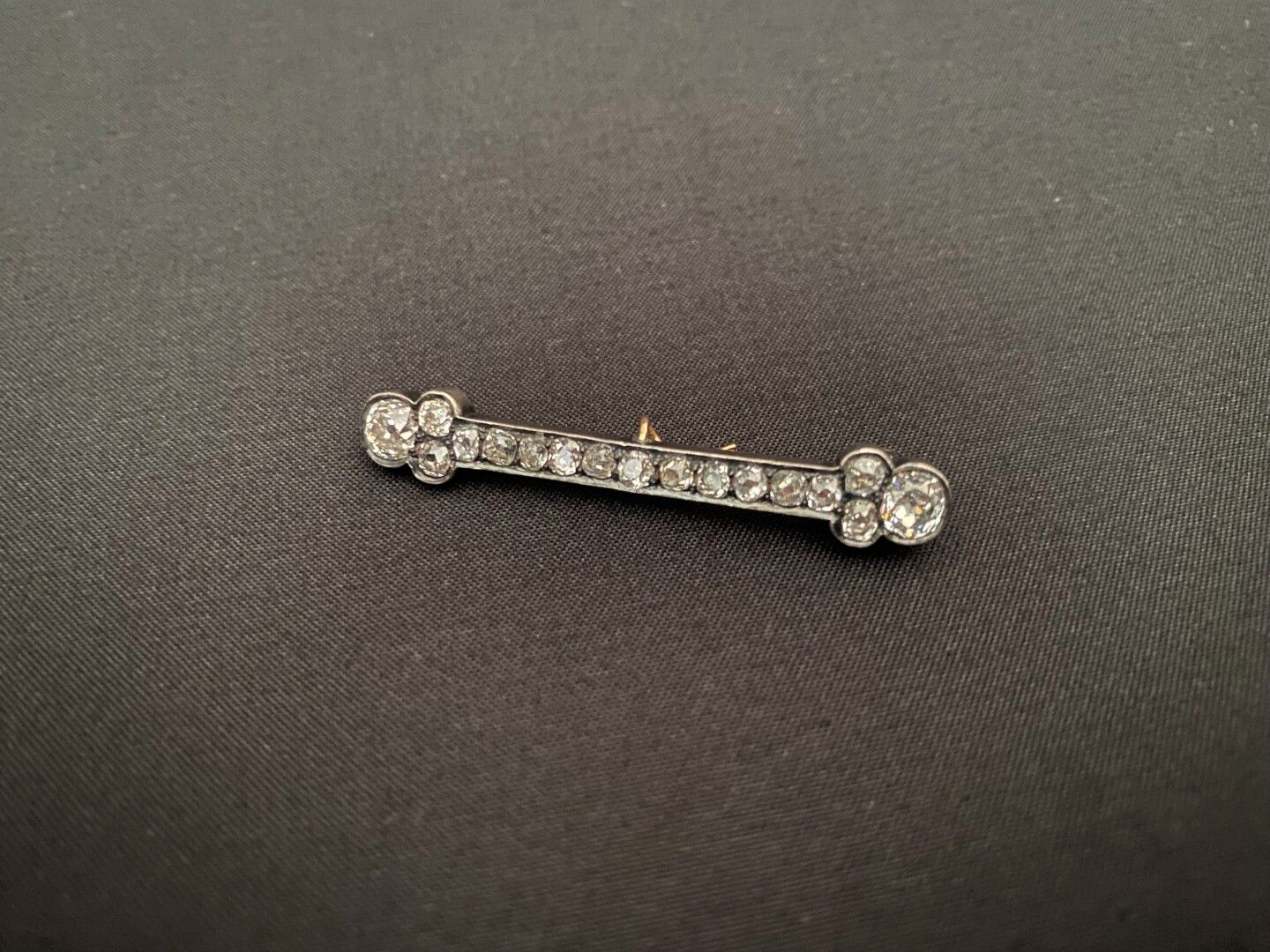 Null 双金线条胸针，镶嵌17颗封闭式老式切割小钻石，包括两端较大的钻石，每颗约0.33克拉 - 总重量：5.1克