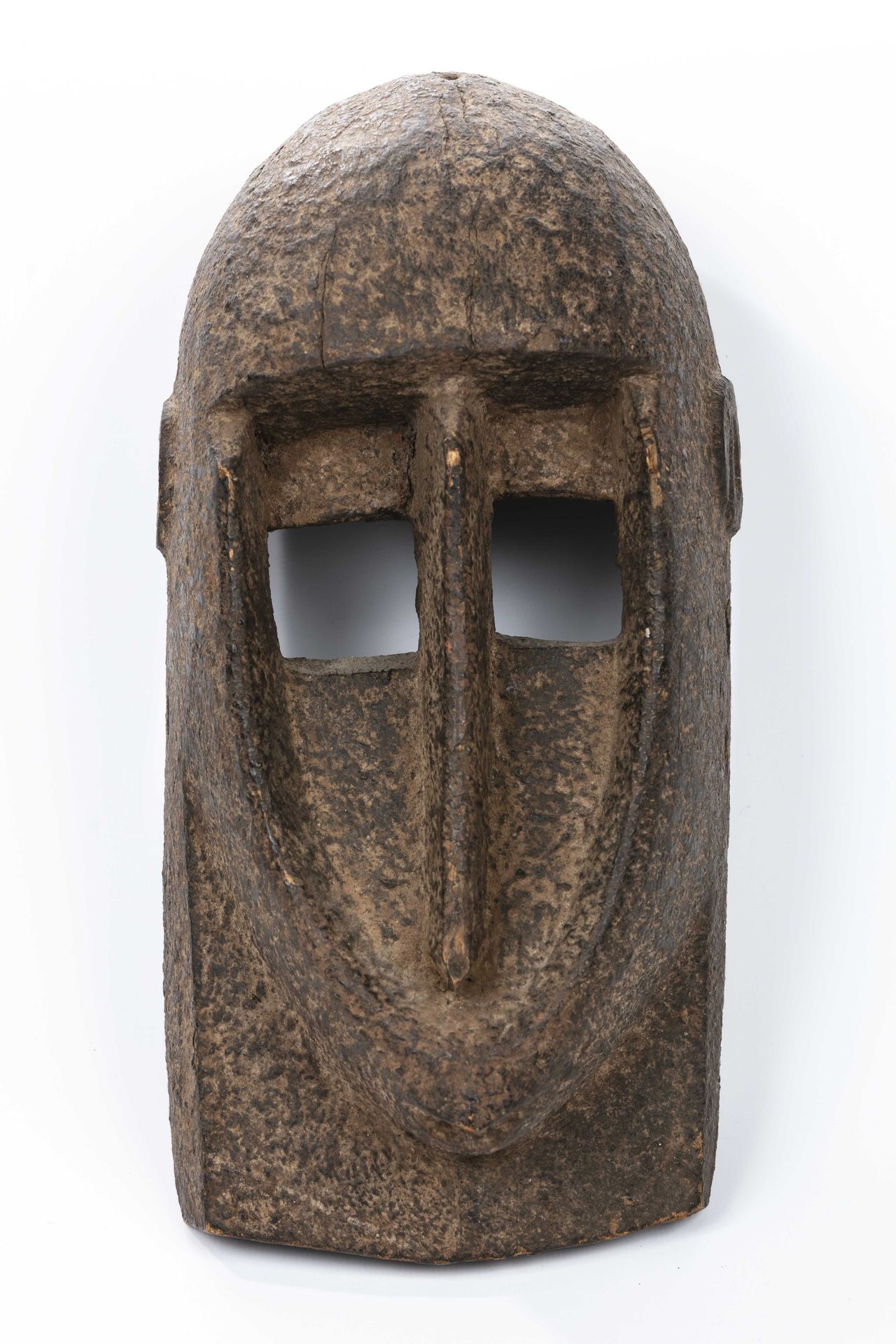 Null 多贡风格的面具，马里 
有锈迹的木材 
高度：29厘米 
头盔式面具，圆锥状，圆顶状，均为长条形，额头为卵圆形，面部底部为椭圆形。这些曲线的柔和性与鼻&hellip;