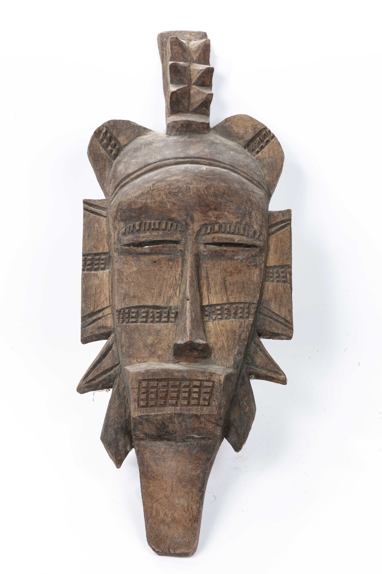 Null 塞努弗面具，象牙海岸 
木头 
高度：52厘米 
长而直的木头脸，有淡淡的铜锈，外围被侧面的添加物（耳朵、胡须）放大了。敞开的长方形大嘴，从里面喷出一&hellip;