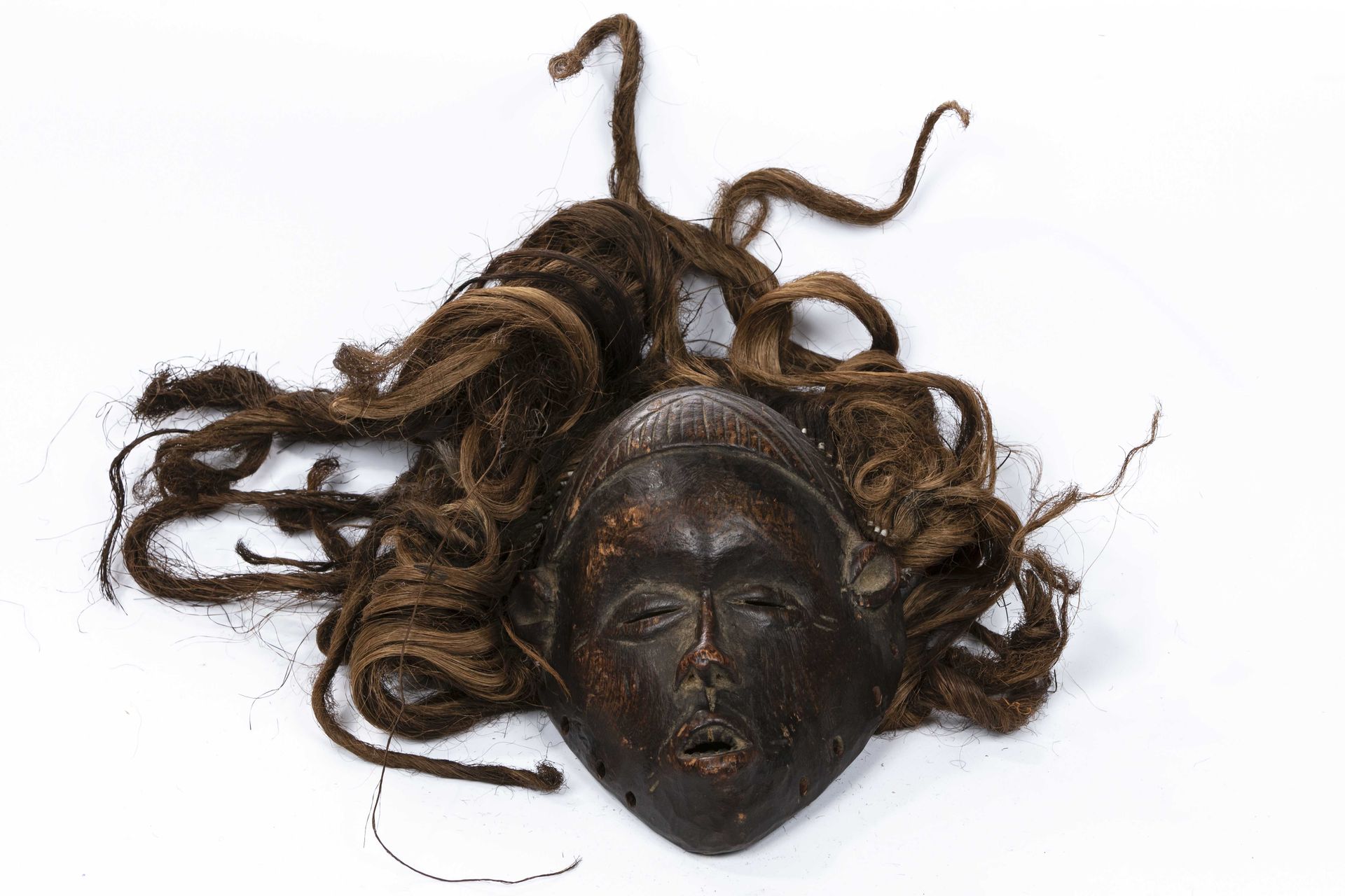 Null 当代非洲面具
木材、毛发纤维、金属
高：约22厘米
面具上有棕色的铜锈，显示出一张小脸，张着嘴，似乎在说话。凹陷的眼睛在浮雕中凸显出小的目光。额头是圆&hellip;