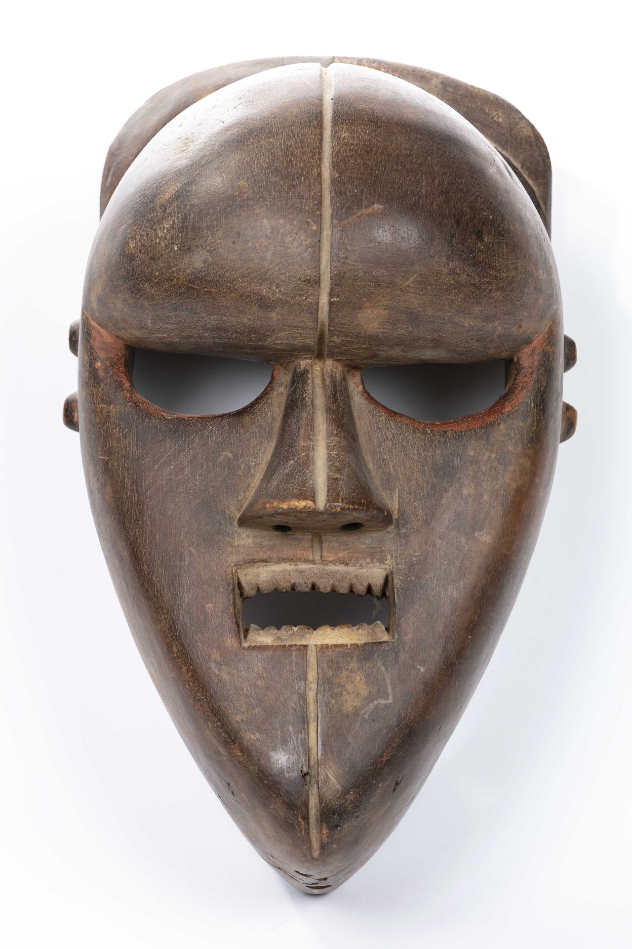 Null 萨兰帕苏风格的面具，民主刚果共和国 
木头 
高度：35.5厘米 
圆润的前额的柔和性与脸部下半部分的棱角分明的三角形形成对比，使面具表现出强烈的严肃&hellip;