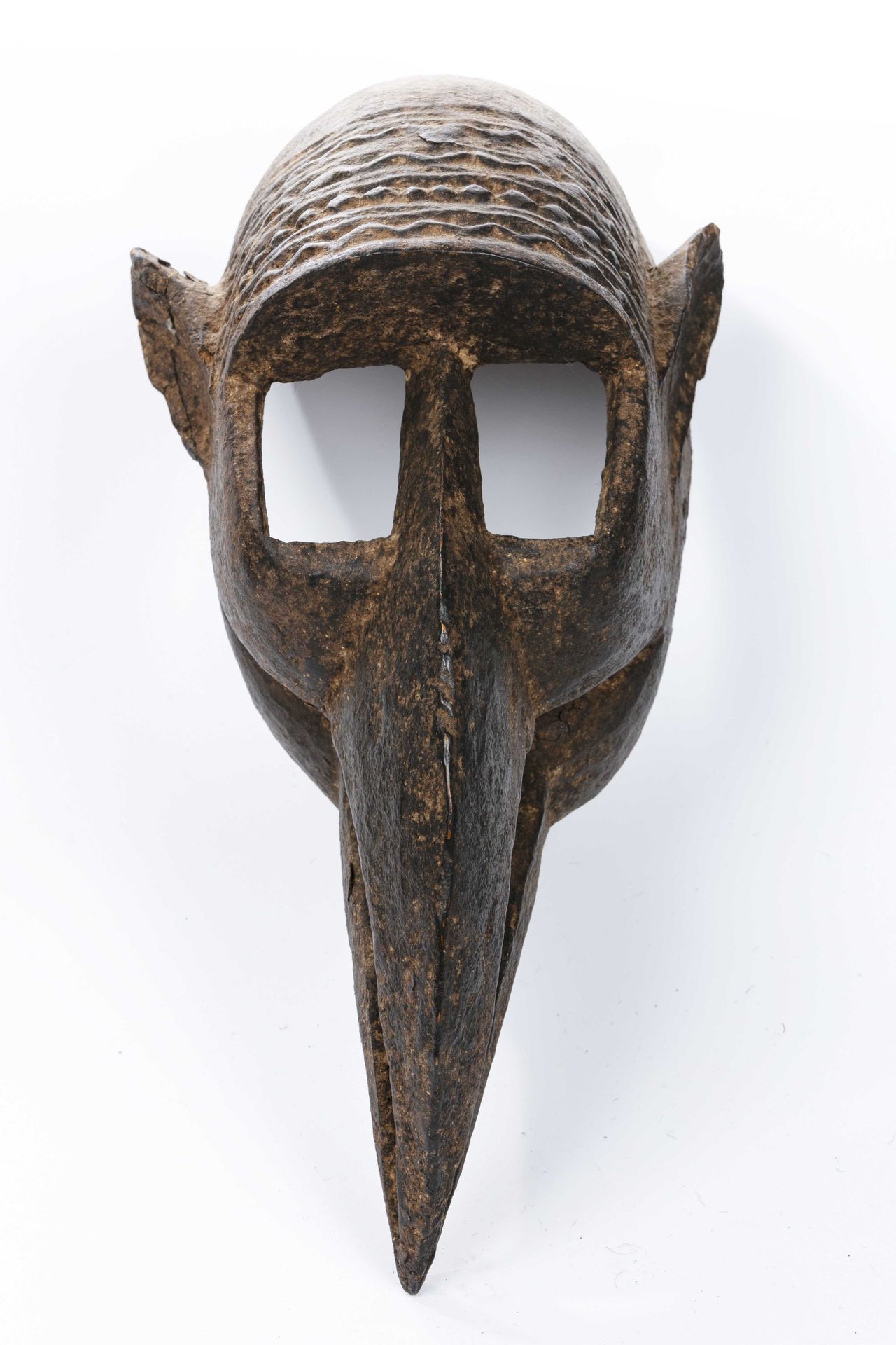 Null 多贡面具 
马里 
木头
高度：46厘米
变形面具，具有图式化的形式，呈现出强大的棱角分明的鸟嘴，垂下的，由长方形空腔形成的大空心眼，侧面的小尖耳朵。&hellip;