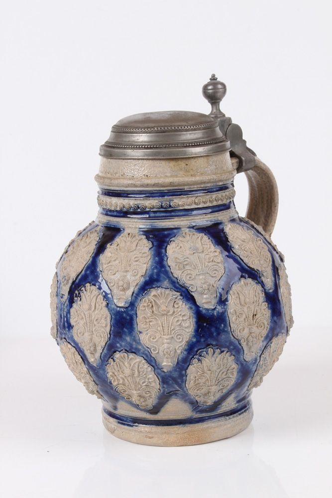 Null 球形壶维斯特瓦尔德，约 1700 年，石器。灰色壶身，施盐釉和钴蓝色彩绘。四周装饰有花瓶印章。凹槽卷柄，锡制底座。高：17.5 厘米。