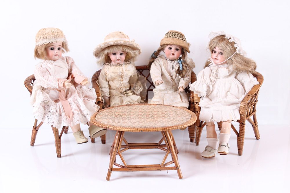 Null Quatre poupées sur un siège. Porcelaine biscuit, corps en masse ou en cuir.&hellip;