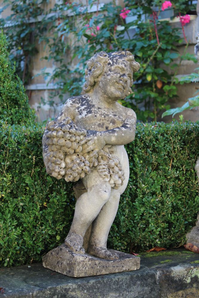 Null 花园雕塑。铸石。手持葡萄的普托站在方形基座上。高：70 厘米。