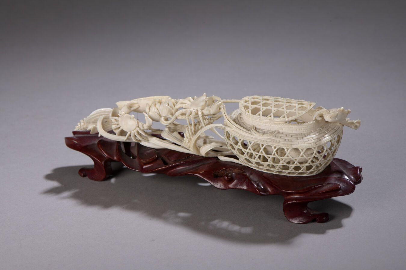 Null 雕刻的象牙和服上有一篮子的螃蟹和莲花。轻微损坏。雕刻的木质底座。日本，明治后期（1868-1912）。长21.5厘米，净重 xxxx克。