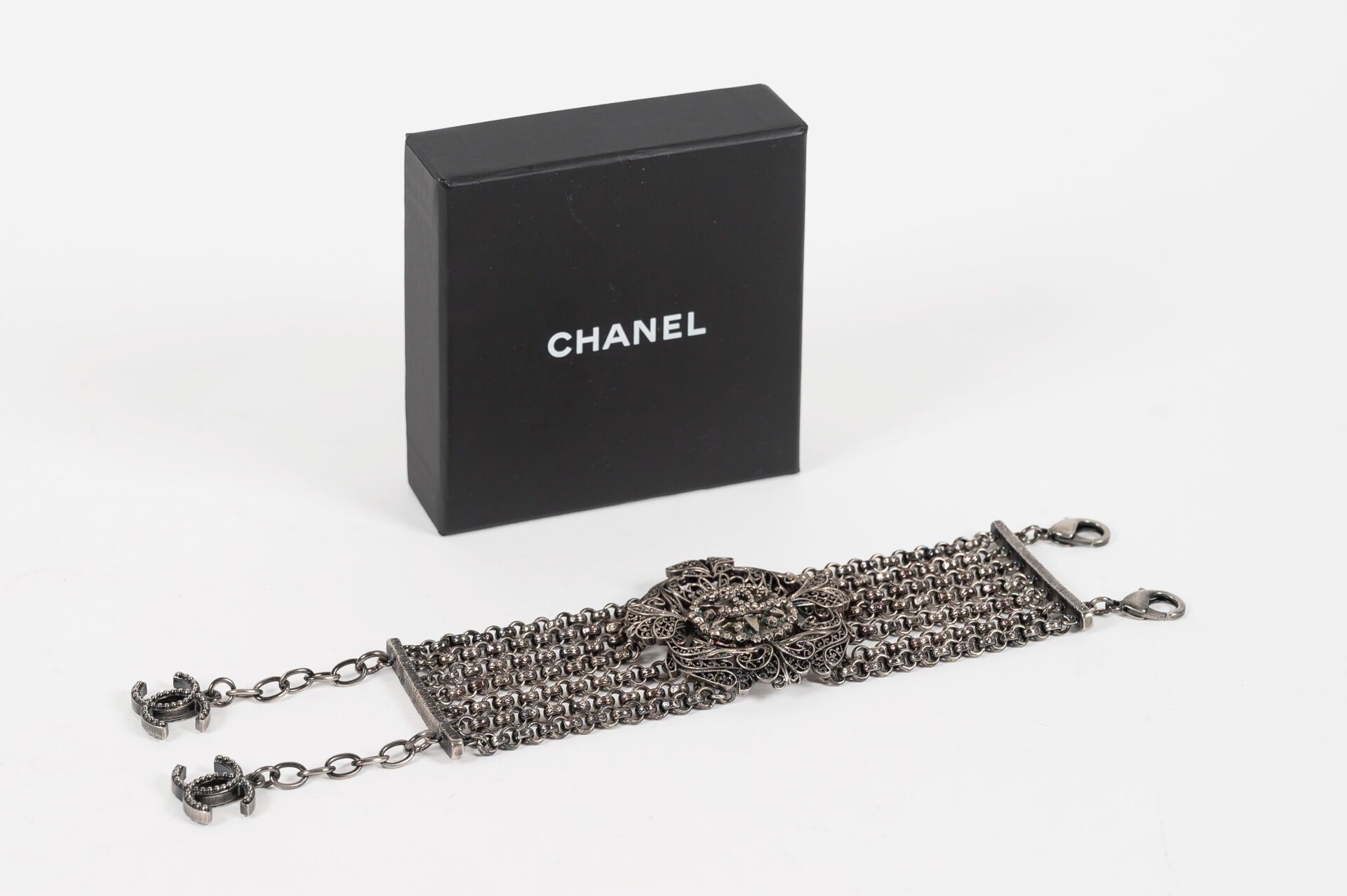 CHANEL Bracelet en métal argenté légèrement noirci à sept chaines retenant un mo&hellip;