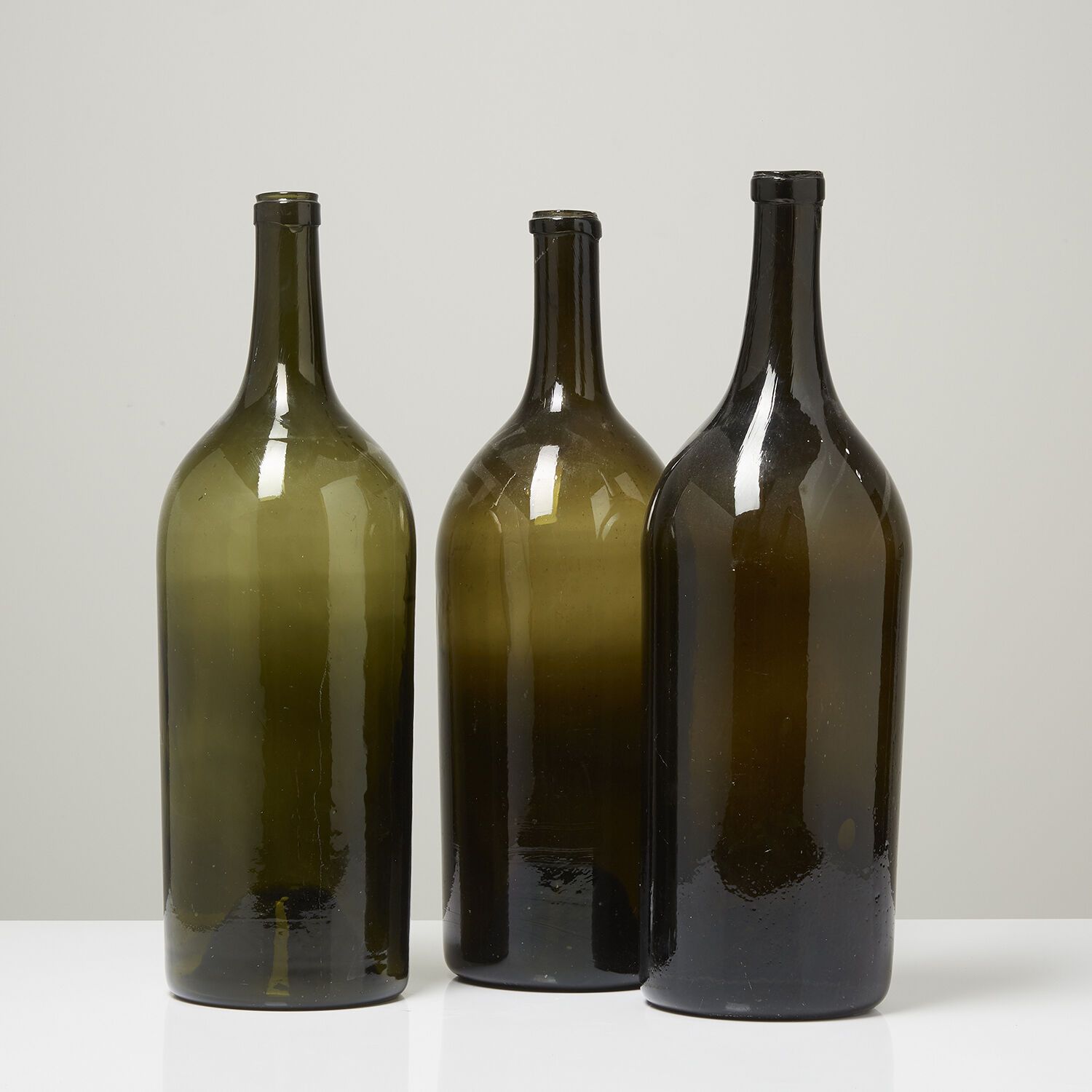 LOT DE TROIS MAGNUMS EN VERRE TEINTÉ VERT, ÉPOQUE XVIIIe SIÈCLE 一套三个绿色有色玻璃大酒杯。

&hellip;