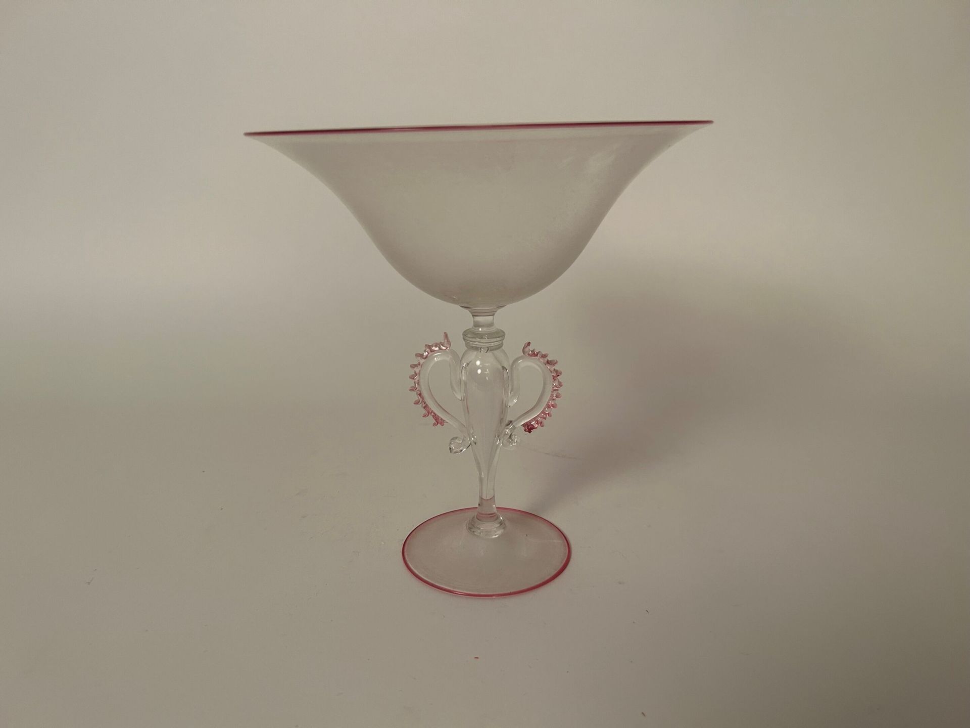 MURANO - DANS LE GOÛT DU XVIII siècle 村野 - 十八世纪风格 
浅色玻璃底碗，碗沿和底座均饰有精美的粉色边框。 
吹制的柄&hellip;