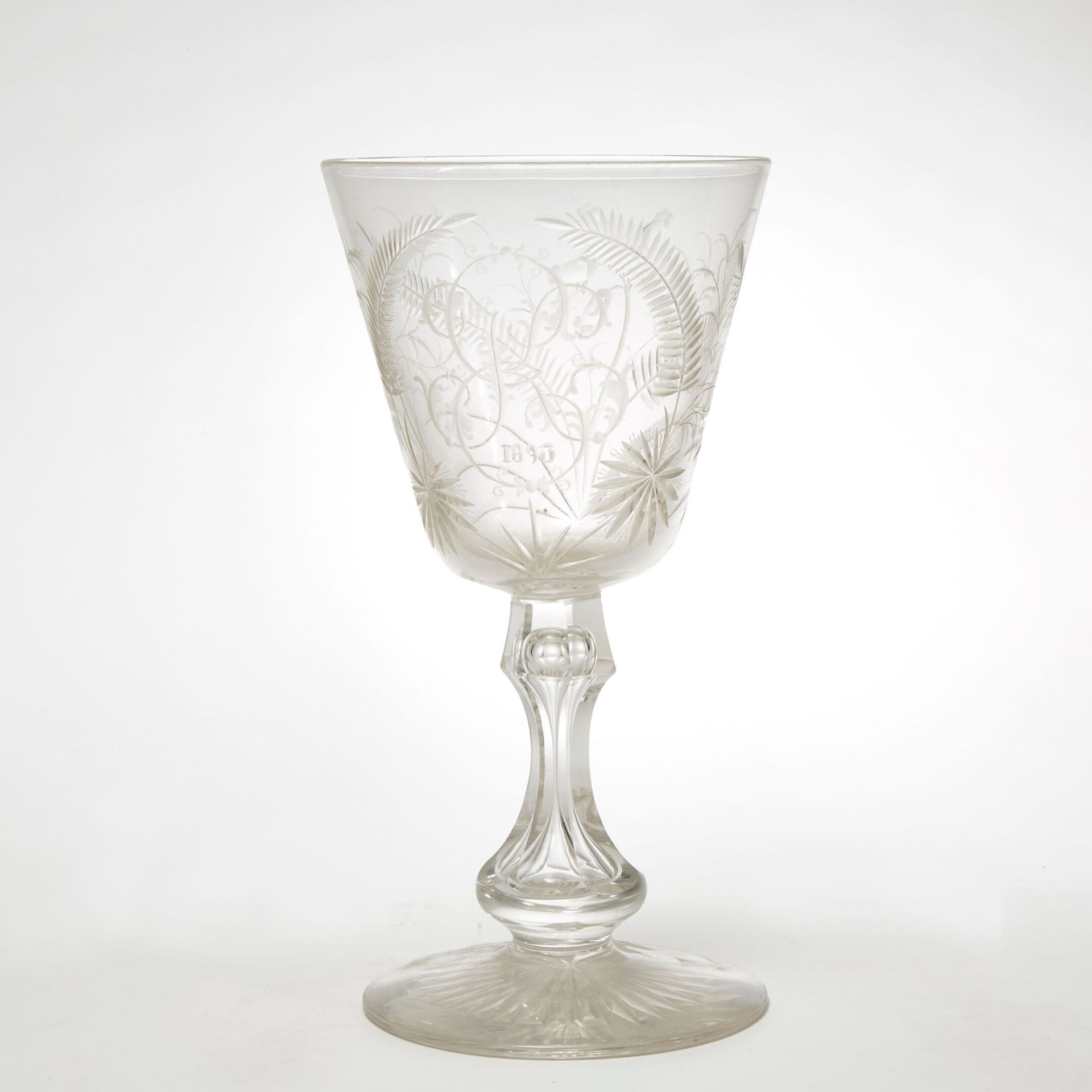 XIX SIÈCLE 19 世纪
一个大型水晶柱柄玻璃杯，刻有大棕榈和树枝的雕刻装饰，中间有一个 KE 字母，日期为 1893 年。 
高 20 厘米。