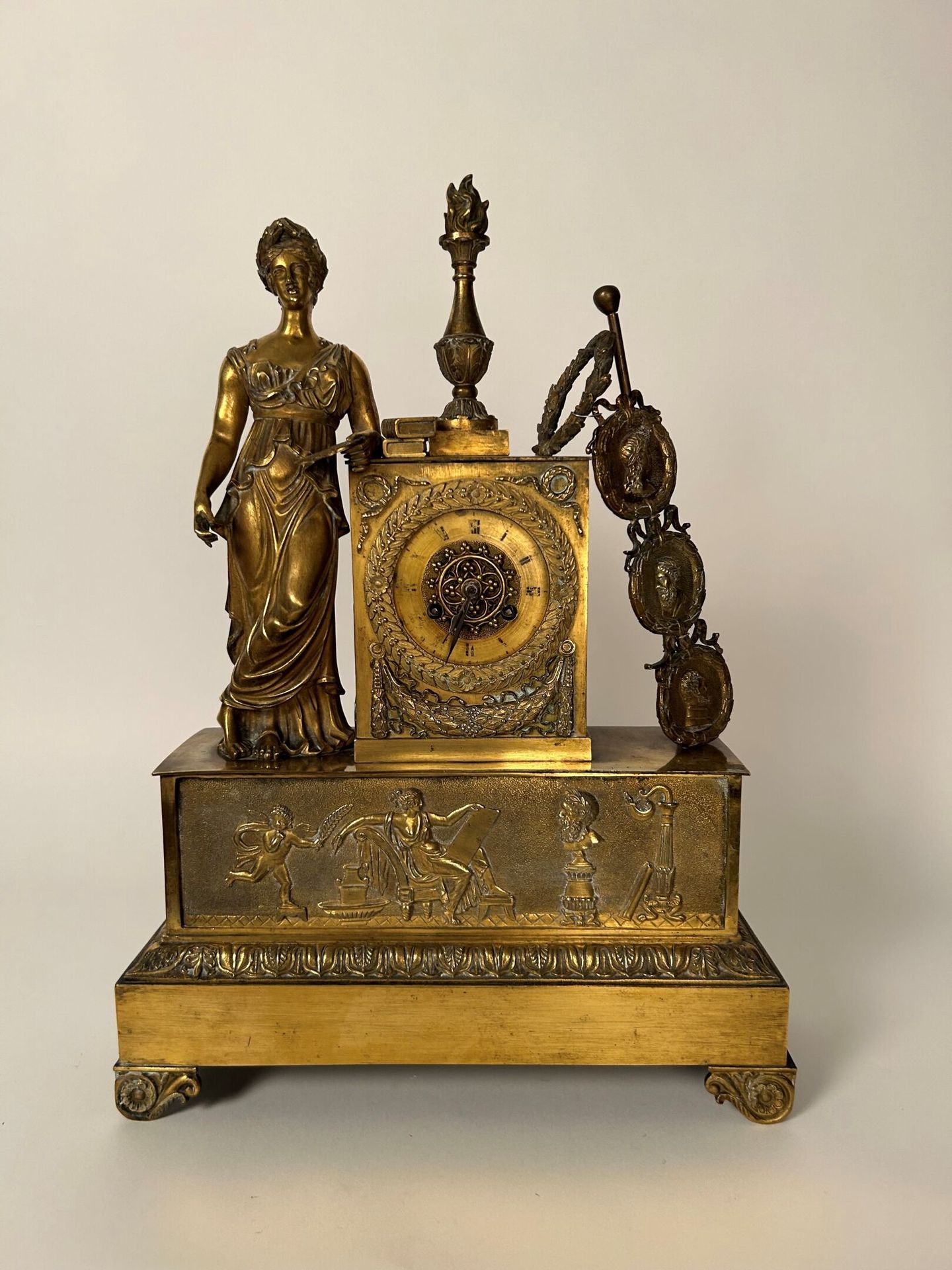 TRAVAIL XIX siècle 19 世纪作品
镀金青铜錾花钟，带有新古典主义装饰，描绘了一位古代风格的女性，寓意艺术。3枚徽章分别代表古式轮廓和皇冠。带&hellip;