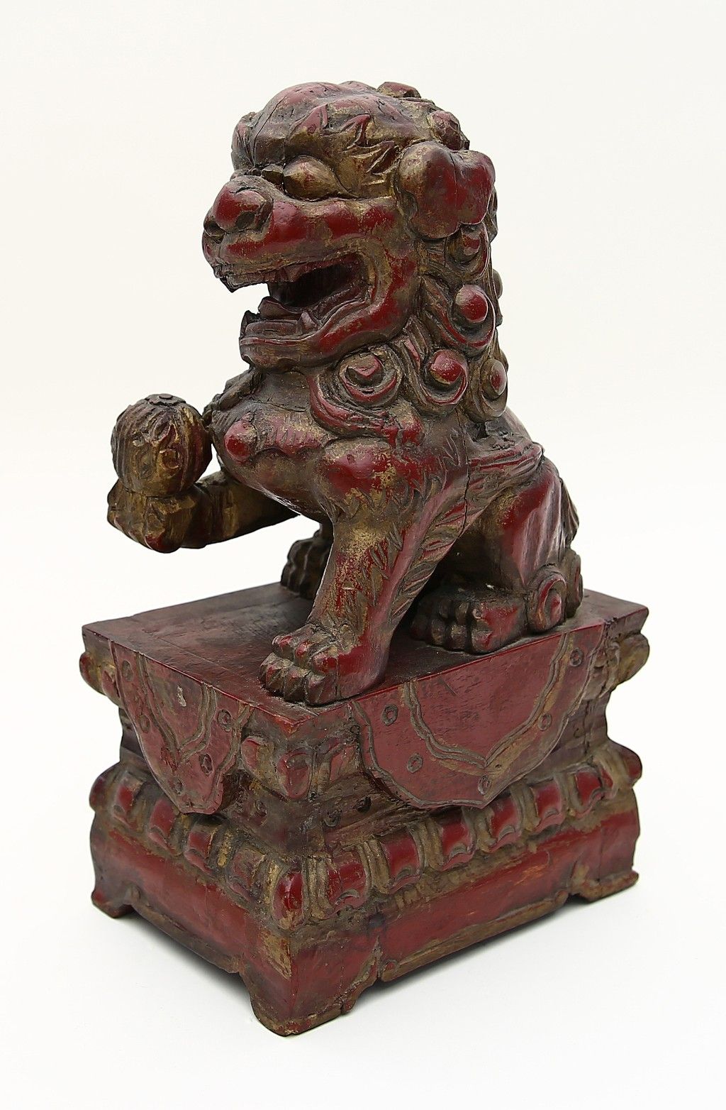 Sitzender Fo-Hund auf Podest. 木质，雕刻。红色漆面，有以前部分镀金的残留物。有岁月的痕迹和应力裂纹。中国，19世纪，高31厘米。