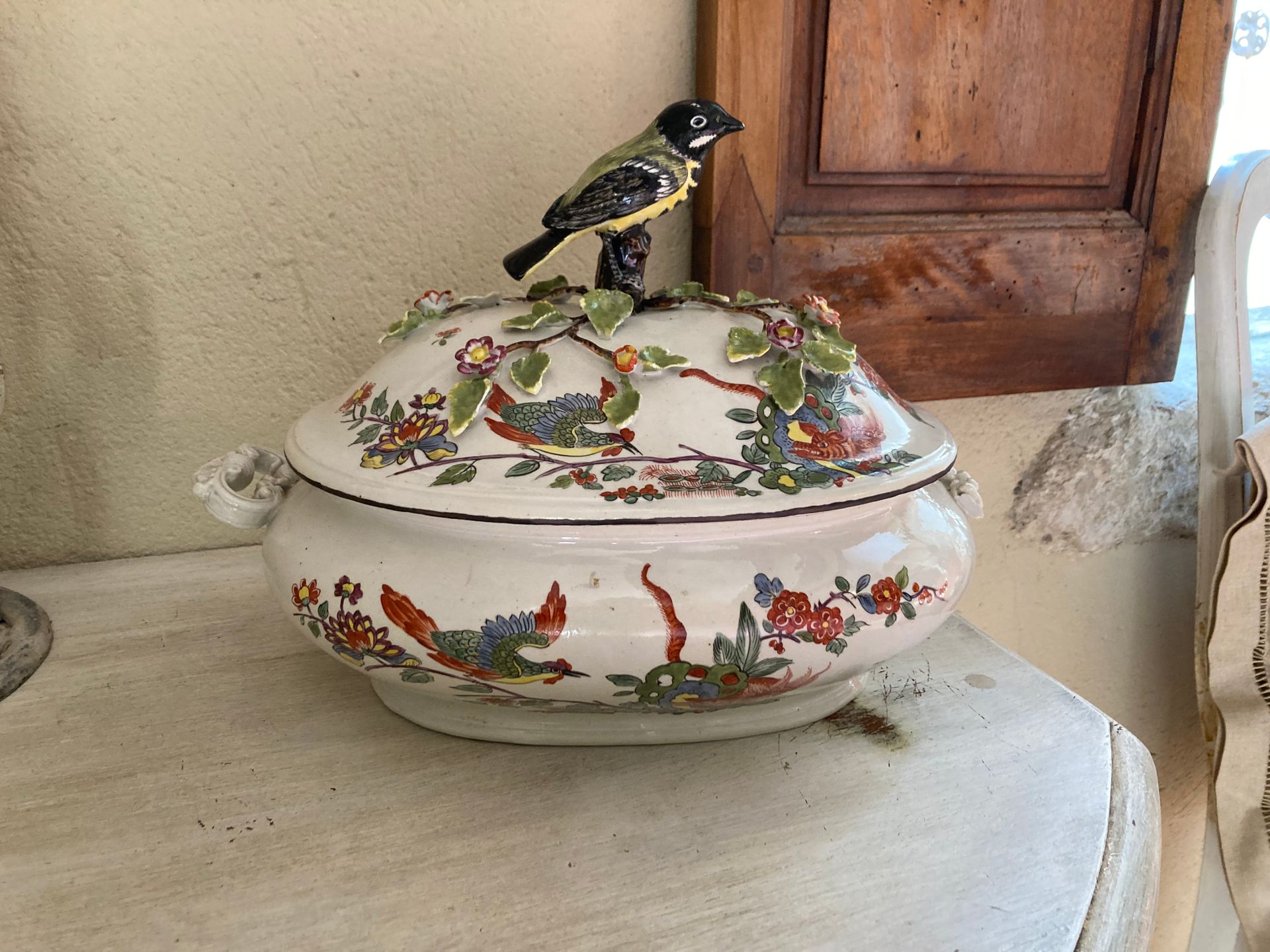 Null 多色珐琅彩陶瓷的汤锅，装饰有鸟类，奇妙的动物和花朵的贴花。手柄是一个鸟的形状。
(损坏)
H.26 cm L. 32 cm