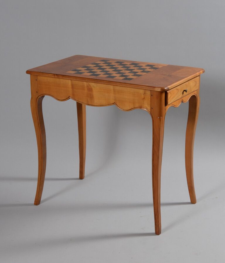 Null 樱桃木游戏桌，凸形腿上开有一个抽屉，顶部镶嵌有棋盘格图案。

路易十五风格，20世纪

高72.5厘米，宽77厘米，深47.5厘米