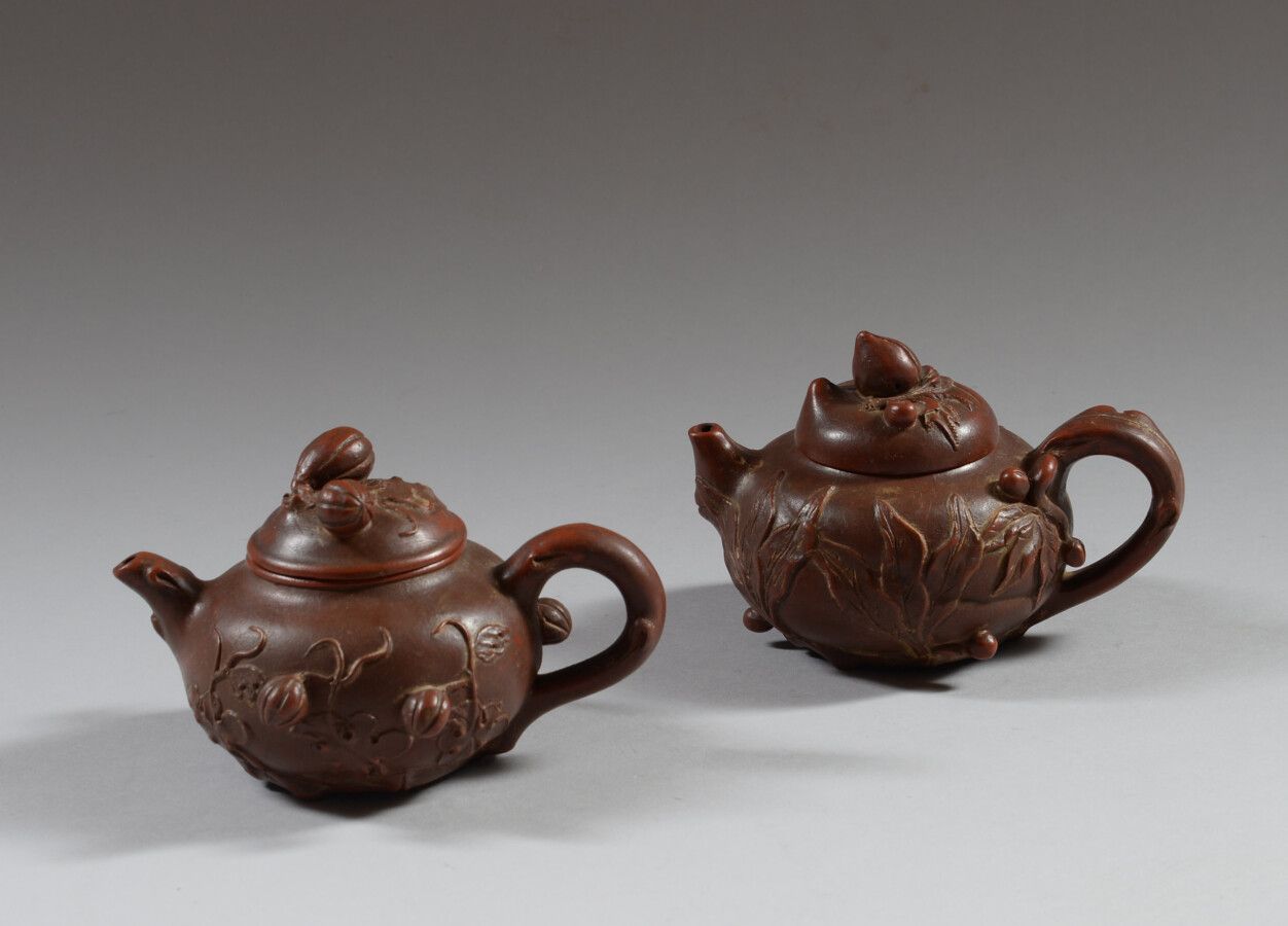 Null 中国

两把宜兴陶制茶壶，浮雕装饰有水果和叶子。背面有刻痕。

高9厘米