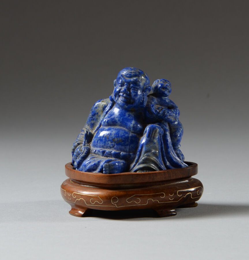 Null CHINA.

Seated laughing Buddha in lapis lazuli on a wooden base.

Dim: 5,5x&hellip;