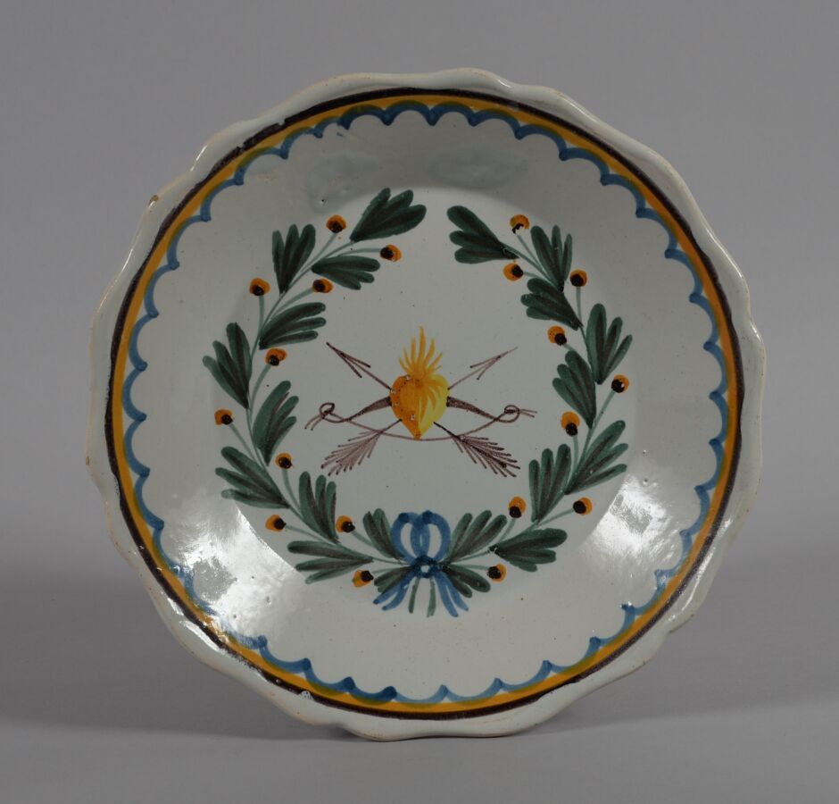 Null ǞǞǞ
一个多色陶盘，上面装饰着一颗心，上面有一张弓和两支箭，周围有一个花环。
18世纪末和19世纪初
直径22.5厘米
BE