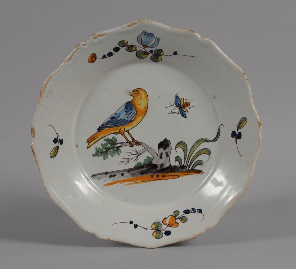 Null 罗歇勒（LA ROCHELLE
一个多色陶盘，装饰着一只栖息在树枝上的大鸟（牛雀），一只昆虫和翅膀上的花枝。
18世纪
直径23厘米
BE, 芯片