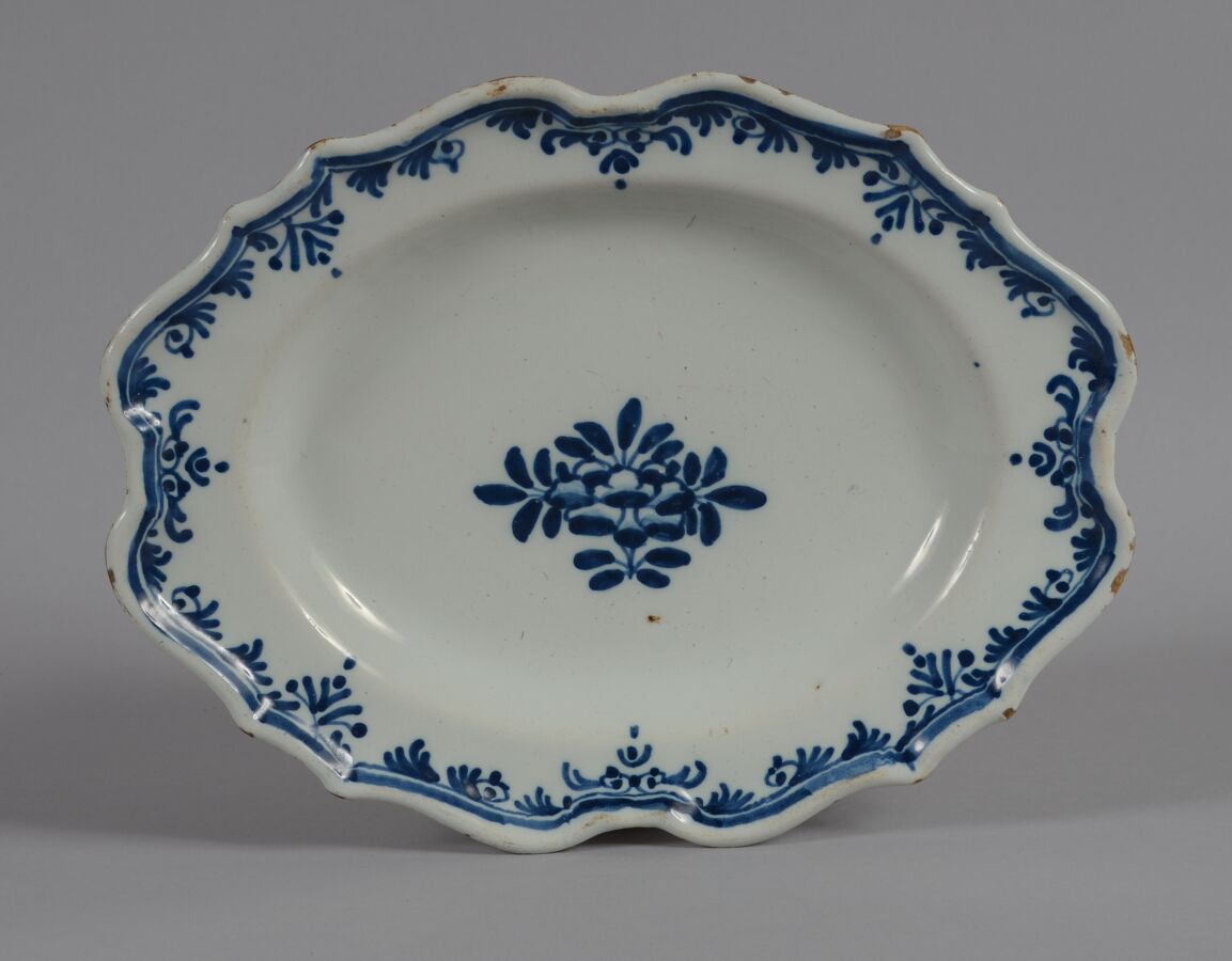 Null AUCH
椭圆形陶器盘，蓝色单色花纹装饰。
18世纪
长30厘米
划痕