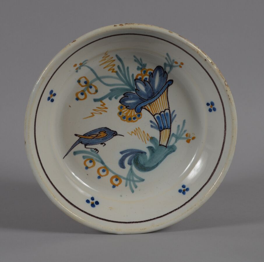 Null SAINTES ?
多色陶器盘，装饰有玉米花和一只鸟。
18世纪晚期
直径22厘米
BE
