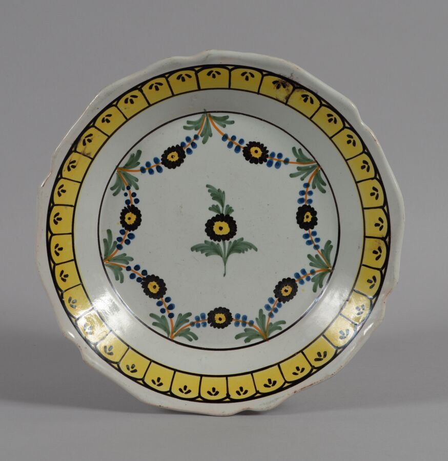 Null NIVERNAIS
一个多色陶盘，中间装饰有花环。
18世纪晚期
直径22.5厘米
BE