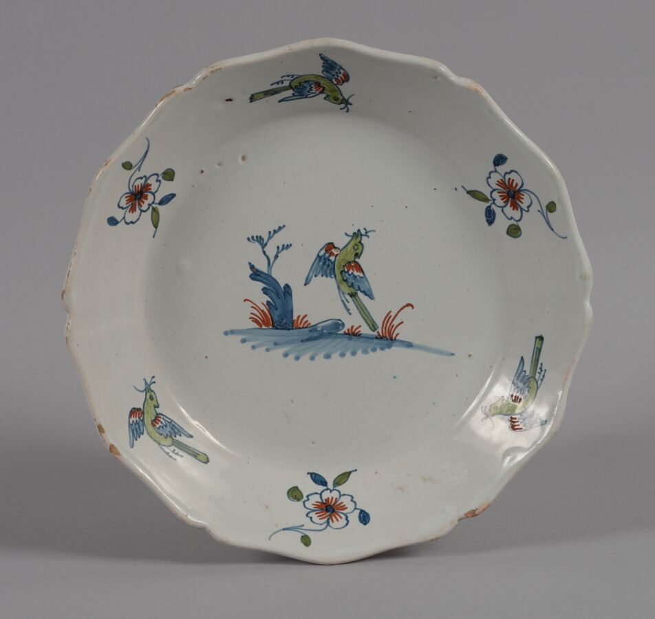 Null 罗歇勒（LA ROCHELLE
陶器盘，轮廓上装饰着一只在土丘上的鸟，鸟和花的翅膀。
18世纪
直径22.5厘米
BE，轻微缺损
