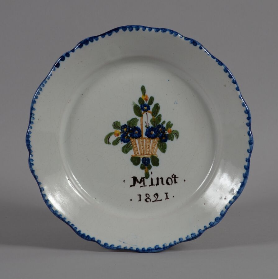 Null VILLERS LES POT
一个多色陶盘，中间装饰着一个花篮，标有 "Minot 1821"。
19世纪
直径21.5厘米
BE