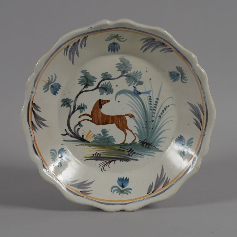 Null ǞǞǞ
一个多色陶器盘，中间有一只狗和一只鸟。
19世纪
直径22.5厘米
恢复了