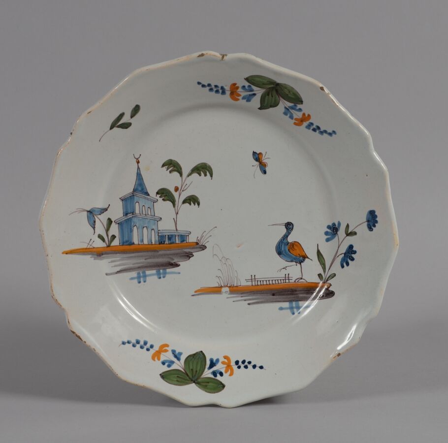 Null 罗歇勒（LA ROCHELLE
一个多色陶盘，装饰有土丘上的涉猎者和宝塔。
18世纪
直径22.5厘米
BE