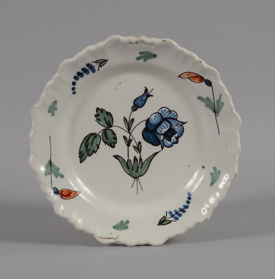 Null 西南地区 
一个多色陶器盘，中间有一朵蓝色的花。
18世纪
直径22厘米
刮痕