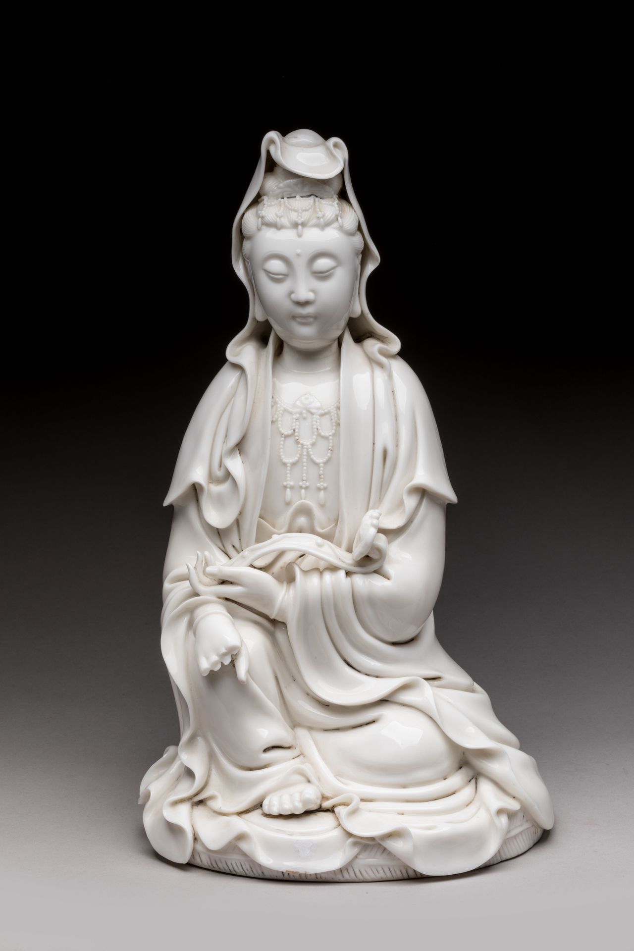 Null 
中国 - 19世纪 


中国白色珐琅彩观音塑像，坐于拉贾里拉萨那（皇家放松），手握如意。背面是双葫芦的德化款和何朝宗款。 


高度：33厘米33&hellip;