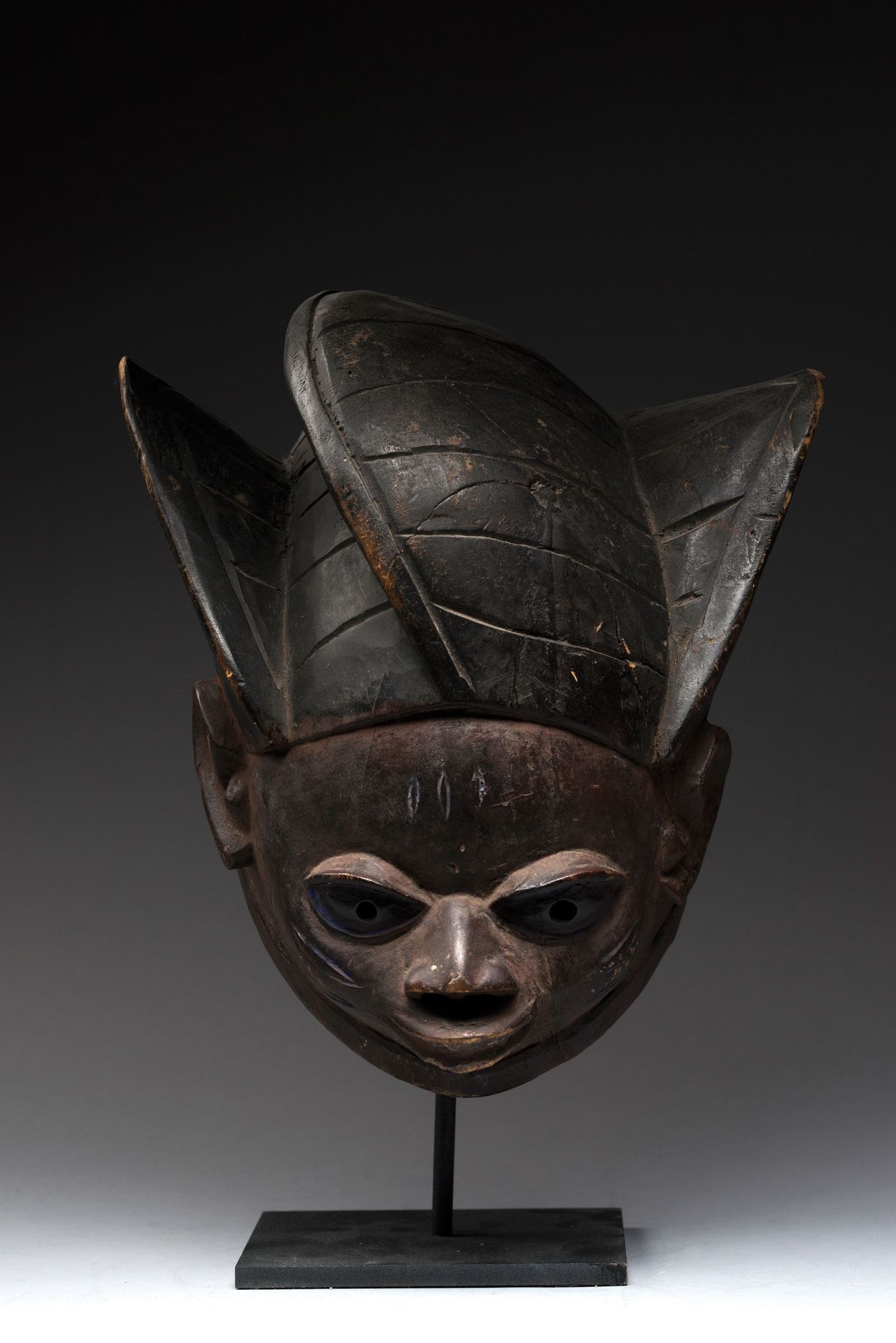 Null 约鲁巴，尼日利亚。 
洛苏头盔面具。 
木头和颜料。男性脸部表情警觉而有活力，脸颊和额头上有疤痕，杏仁形的眼睛有穿孔。有内部搬运的痕迹，有靛蓝颜料的残&hellip;