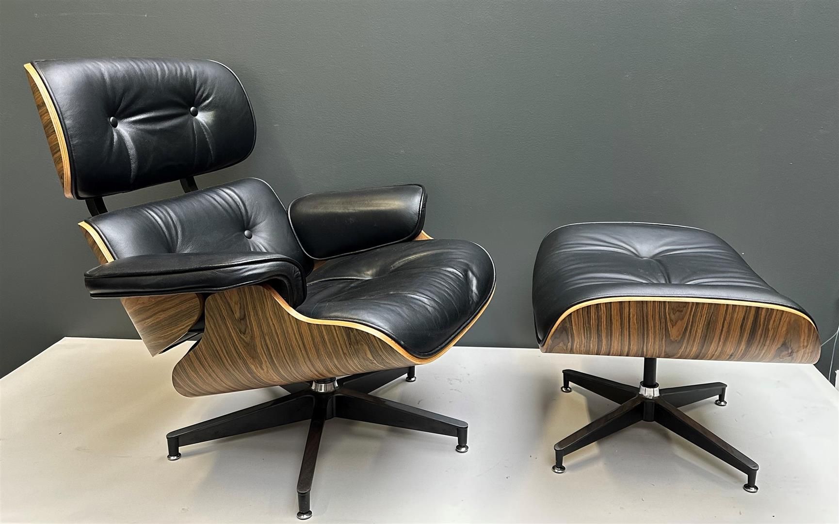 Null 一把黑色皮革设计师椅和长椅，灵感来自查尔斯和雷-伊姆斯的休闲椅和长椅。没有标记。