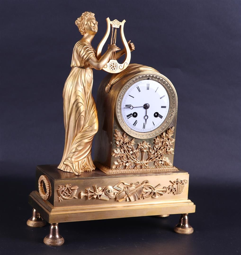 Null 一个19世纪的火镀金壁炉钟，上面有弹奏竖琴的缪斯。
高：37厘米。